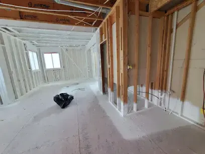 Bright room stripped to the studs after water damage, ready for drying